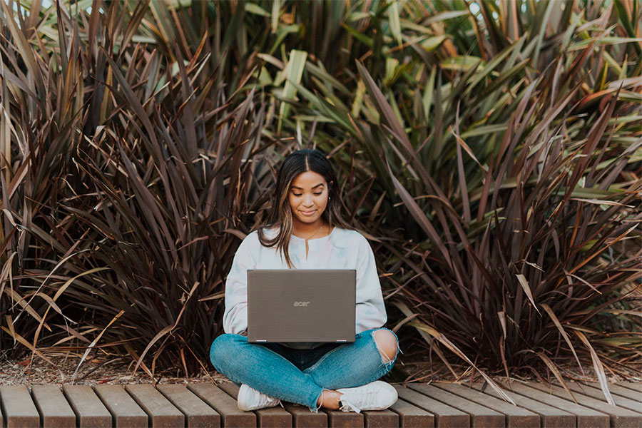 Young woman on laptop outside