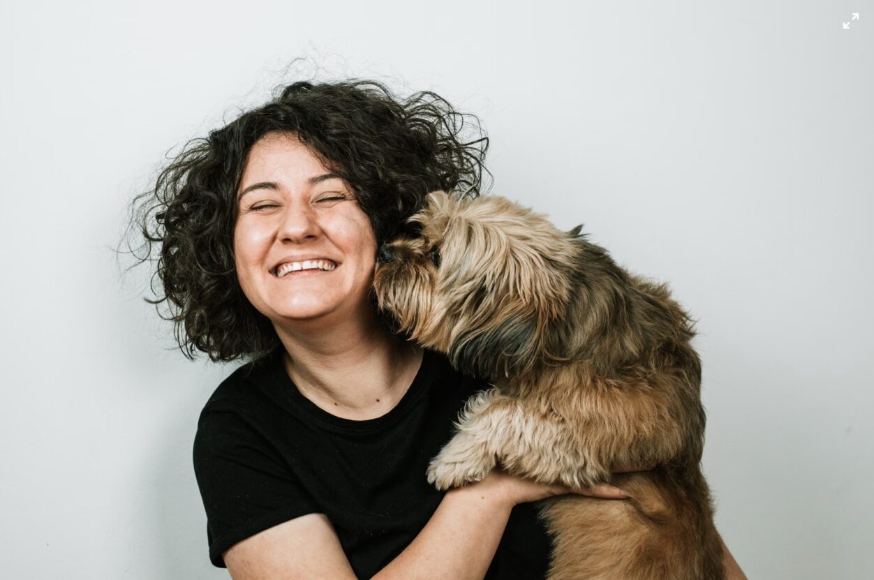 Happy woman cuddling her dog